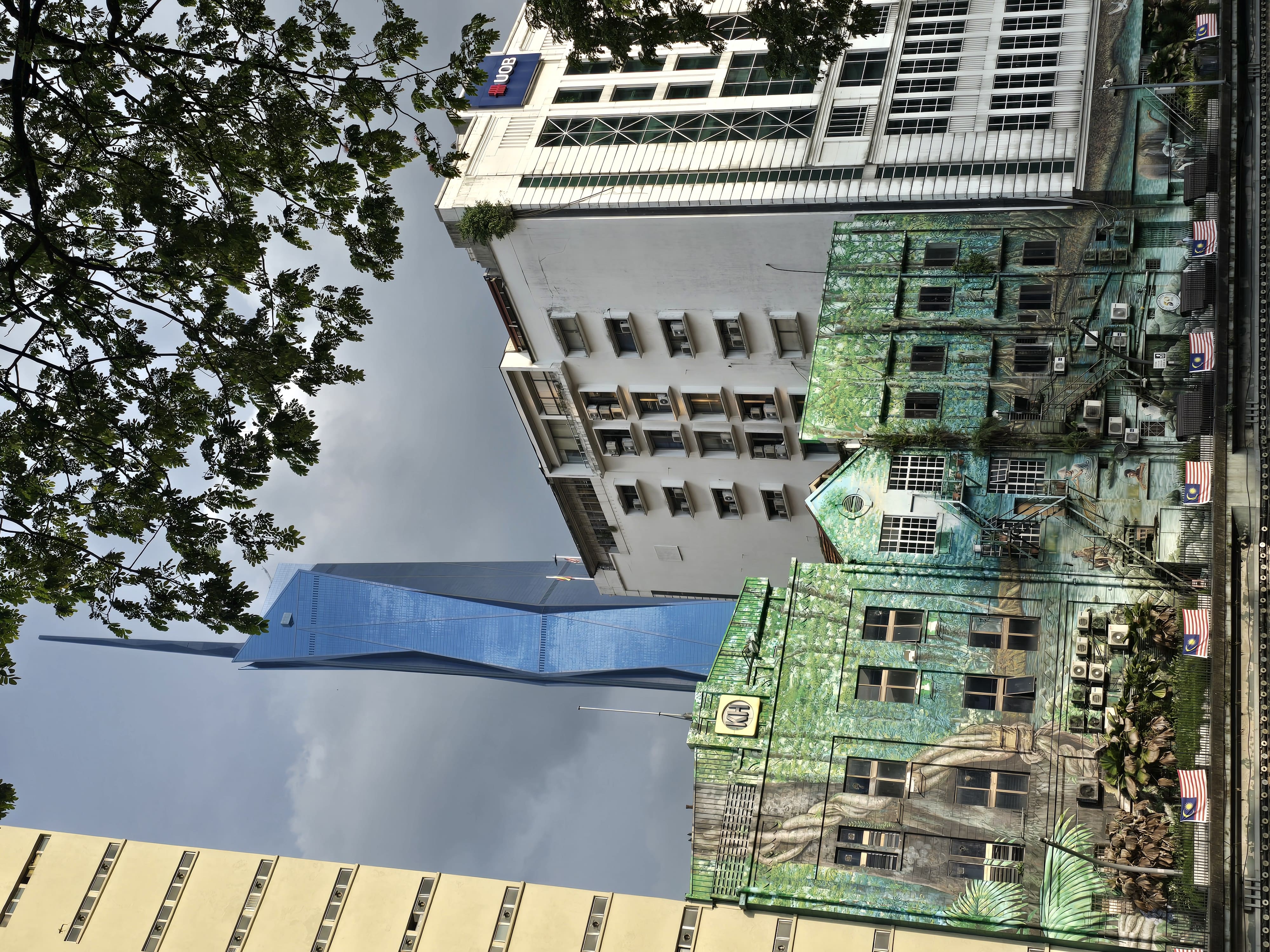 Laagbouw met op de achtergrond een enorme wolkenkrabber Kuala lumpur