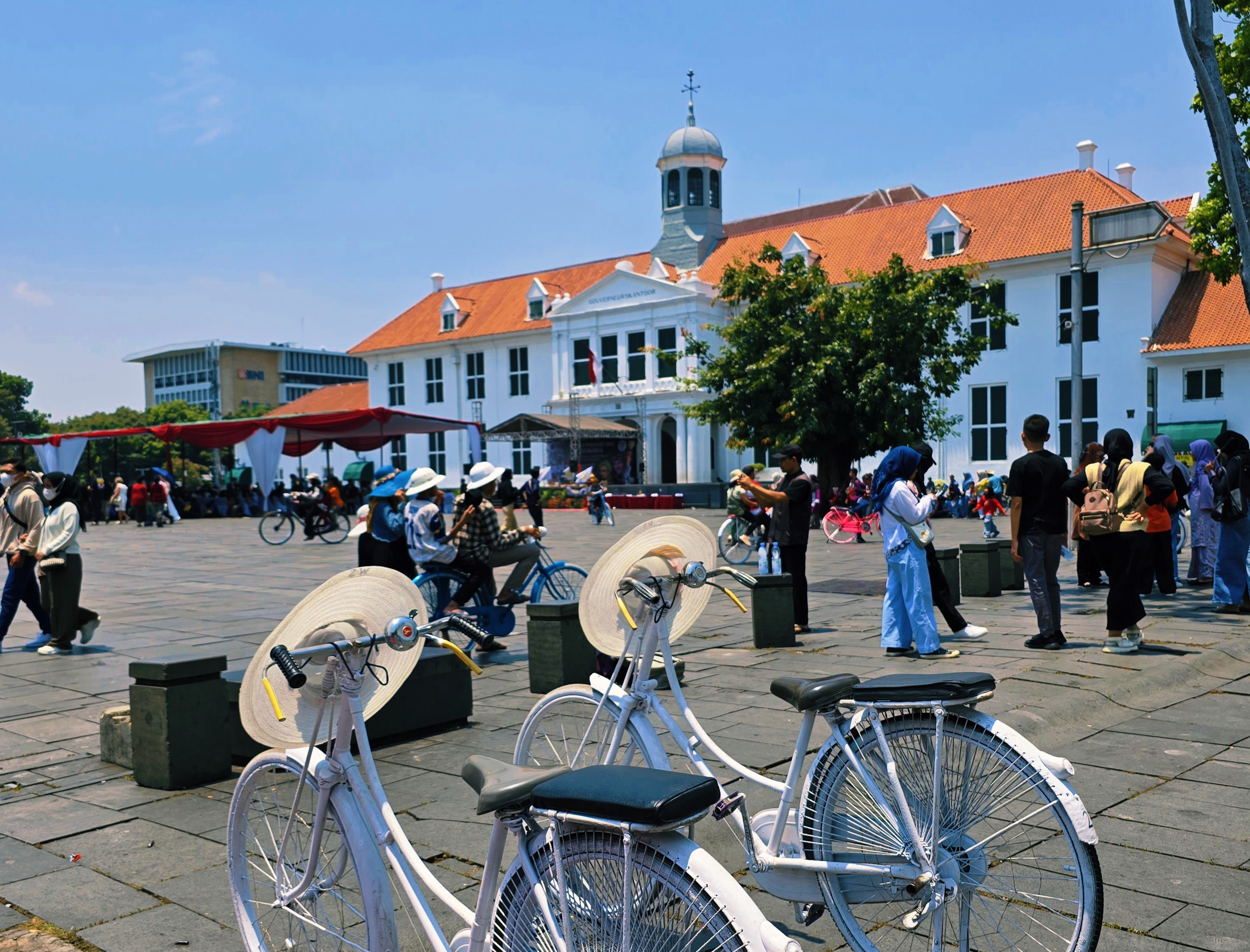 Typische Nederlandse damesfietsen met op de achtergrond een koloniaal gebouw uit de Nederlands-Indische tijd