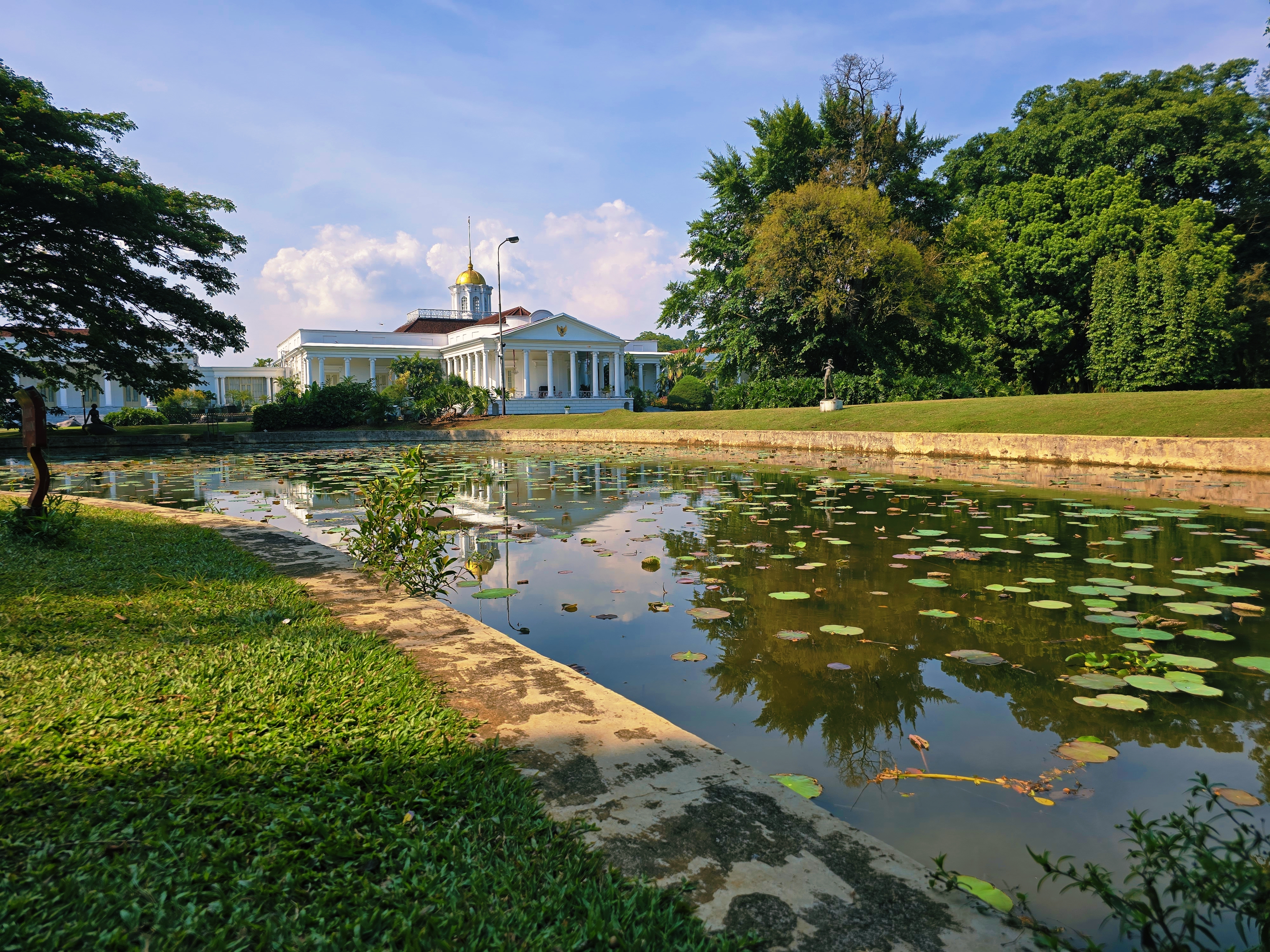 Prachtige tuin met vijver en koloniaal paleis op de achtergrond